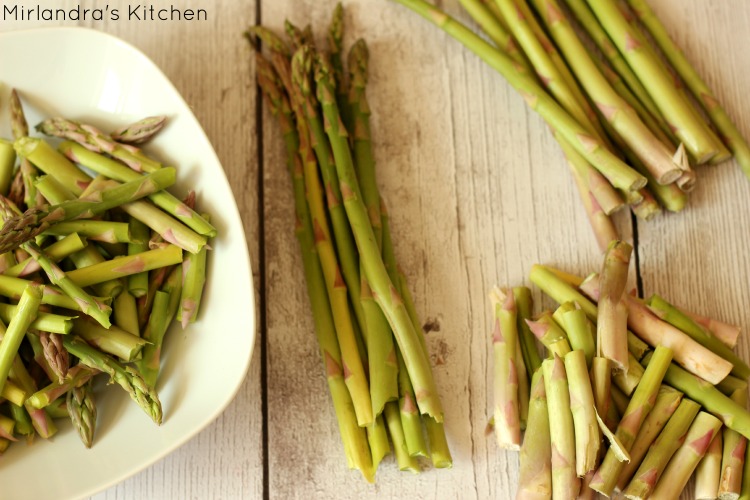 Asparagus waarvan de onderkant wordt afgebroken.